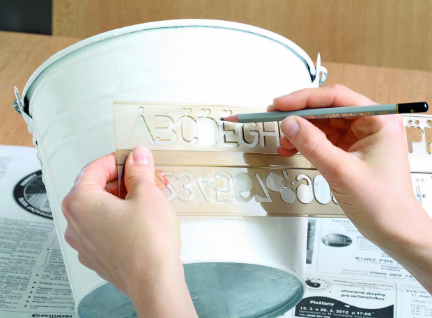 Když barva uschne, napište na kbelík pomocí písmenkového pravítka nápis.
