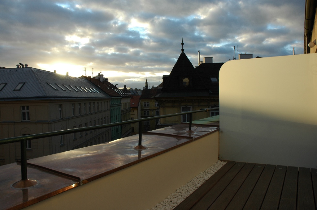 Terasa s romantickým pohledem na střechy domů v centru prahy.