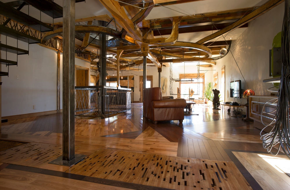 Obývací prostor je vzdušný, zařízený celkem skromně. Na podlaze najdeme ztřeštěnou mozaiku z nejrůznějších druhů dřeva.