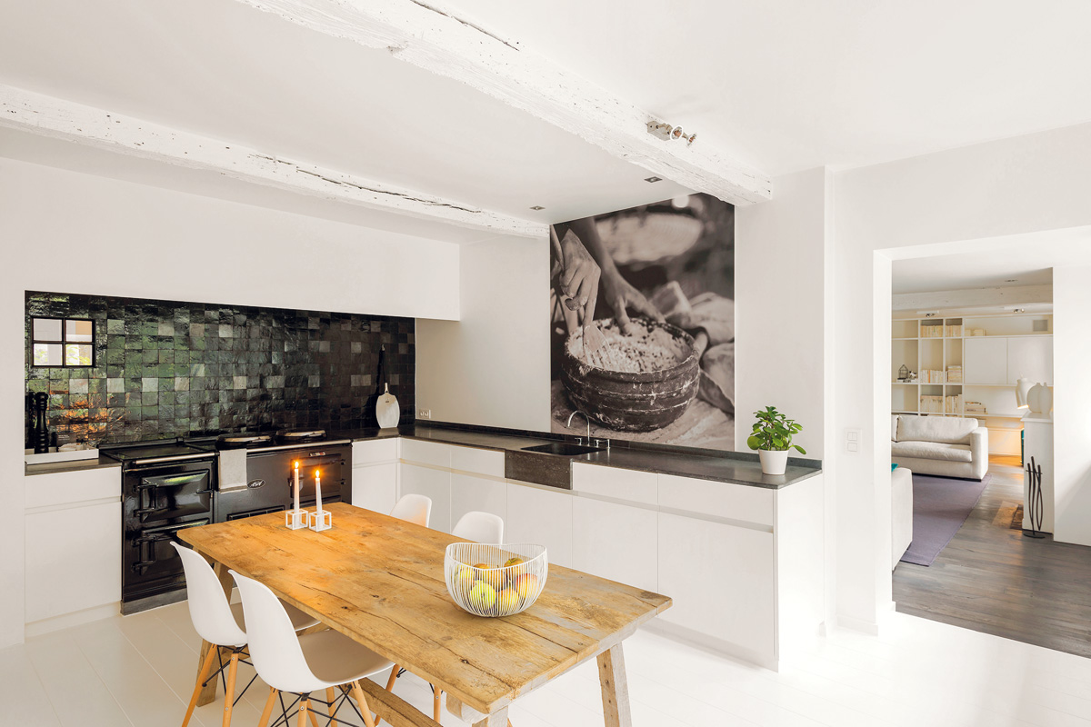 Kuchyň je v přímém kontaktu s obývákem. Spojuje je nejen prostor a kontakt se zahradou, ale i bílé stěny a jednoduché vybavení. Jen původní podlahu z dřevěných desek vystřídala v kuchyni nová bílá dlažba.
