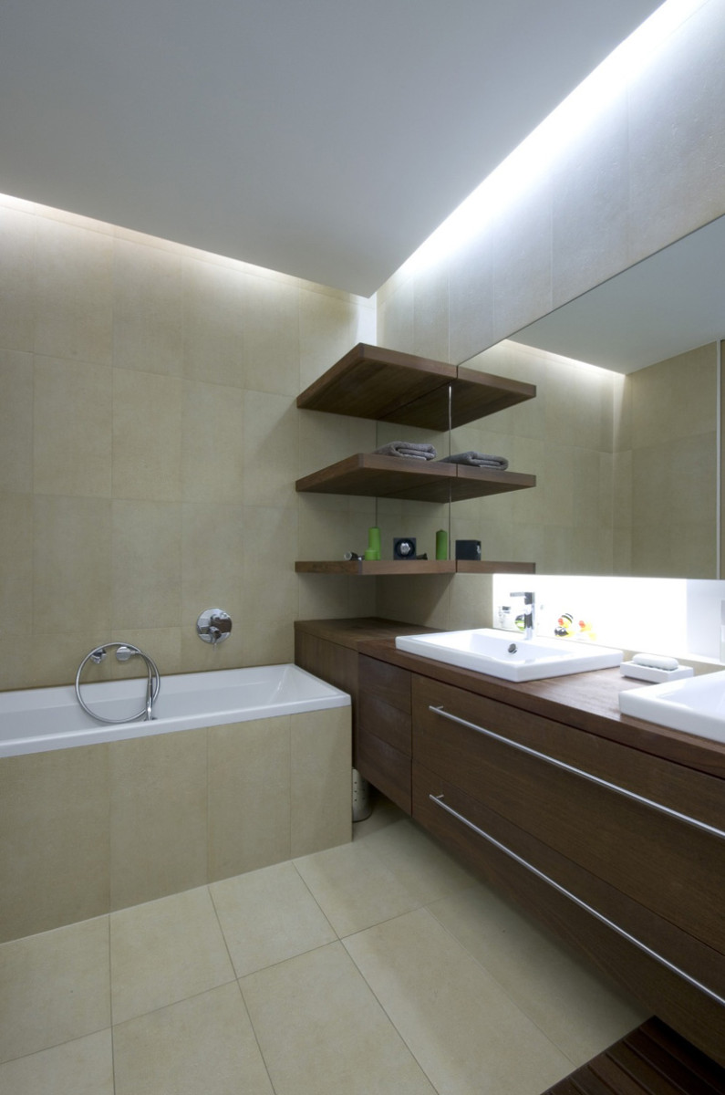 Koupelna v přírodně béžových odstínech s nábytkem z tmavého dřeva.