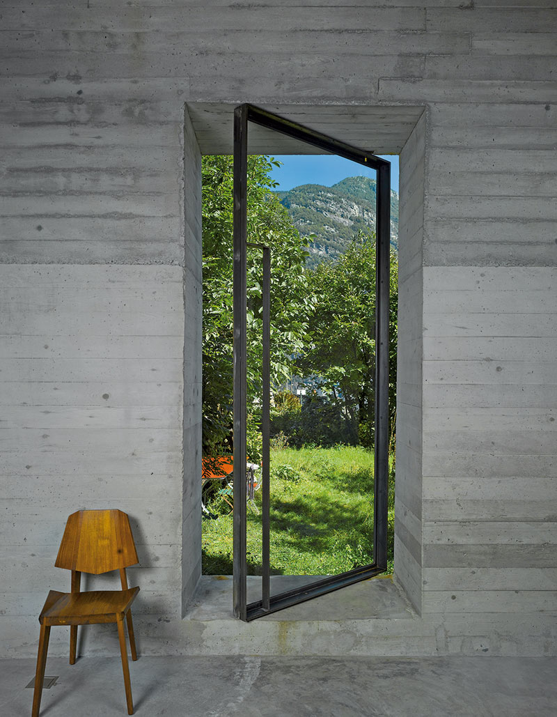 Introvertní budova má jen jedny nové dveře – skleněné v ocelovém rámu, které zároveň poskytují výhled na panorama údolí.