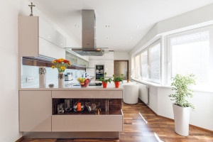 Moderní kuchyňská linka v čistém bílém provedení, barevně akcentovaná jen drobnými předměty a dekoracemi, patří majitelům domu. Foto Inoutic