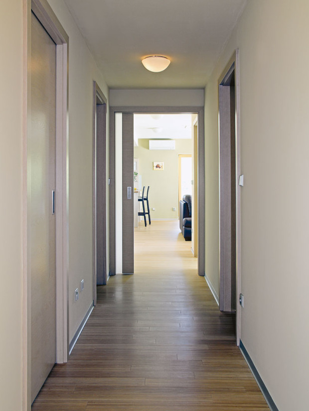 Úzká dlouhá chodba je spojnicí všech místností v domě. Když do ní vstoupíte od hlavního vchodu, vpravo se nám otevře pohled na společný obytný prostor. FOTO ROBERT ŽÁKOVIČ