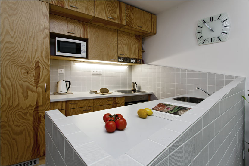 Výrazným prvkem je sešikmení, které řeší obložení stěn i ohraničení celé kuchyňské desky.