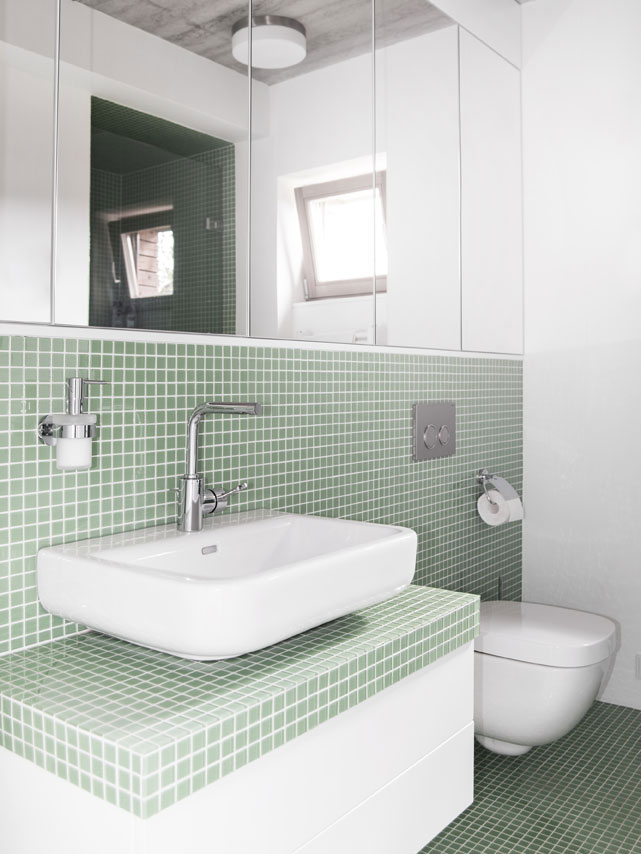 Světlá a střídmá koupelna zaujme kombinací velkých zrcadel a malého formátu mozaiky. Oblíbenost koupelnových mozaik stále roste, zde je aplikována jednoduše a funkčně v odstínu máty. Foto: Vojtěch Veškrna