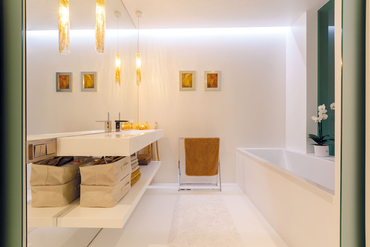Bílo-zlatá koupelna je součástí ložnice i budoáru (vanu od něj dělí pouze matné sklo). Svým pojetím se blíží zařízení obou místností, nejčastějí se využívá pro dlouhé uvolňující koupele, které smyjí stres z dlouhého pracovního dne. FOTO DANO VESELSKÝ