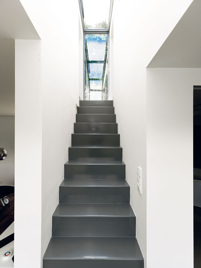 Úzké ocelové schodiště, které vede do druhého podlaží, vedle své praktické funkce plní i roli působivého estetického prvku v interiéru. FOTO Dano Veselský