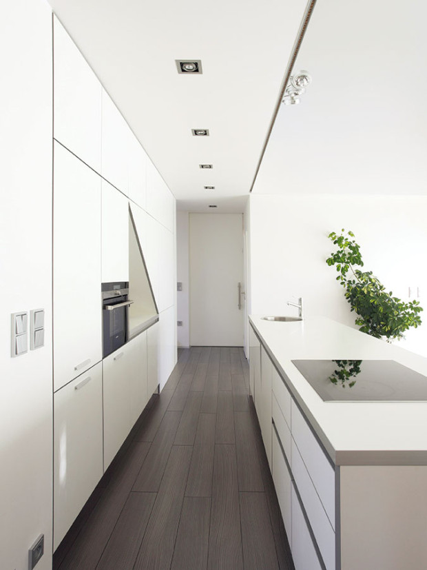 Čistý interiér. V interiéru dominuje racionalita, podpořená například dostatkem chytře poskládaných úložných prostor, a bílá barevnost, zjemněná prvky viditelné dřevěné konstrukce a dřevěné podlahy. Foto Lina Németh
