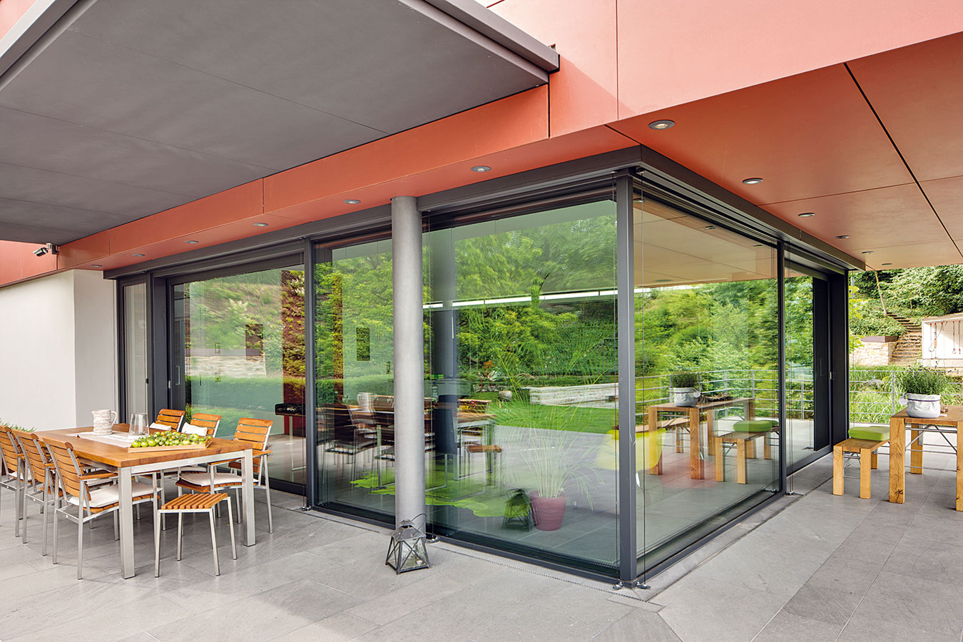 Technologicky sofistikovanou stěnu mezi kuchyní a sousedící terasou tvoří kombinace posuvných dveří a pevných zasklených ploch fasádního systému Schüco.