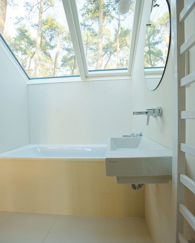 Koupelna s vanou umístěnou pod střešními okny propojuje se zahradou i tuto obvykle velmi intimní část interiéru. FOTO ŠTĚPÁN ZÁLEŠÁK
