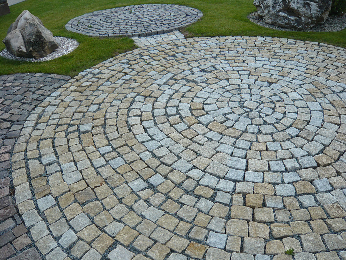Do českých zahrad se čím dál tím častěji vracejí klasické kamenné dlažební kostky.