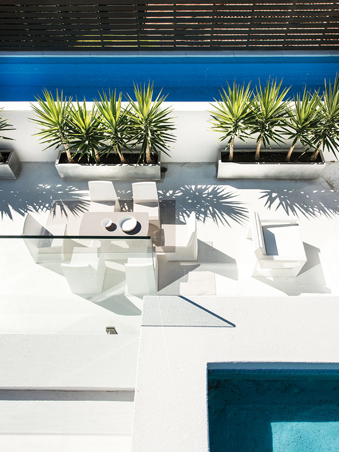 Hlavní terasa, orientovaná na sever, z ptačí perspektivy. Jednolitou bílou plochu narušuje jen barevnost dřevěného plotu, vysazených rostlin a azurová modř bazénové vody. FOTO DMAX
