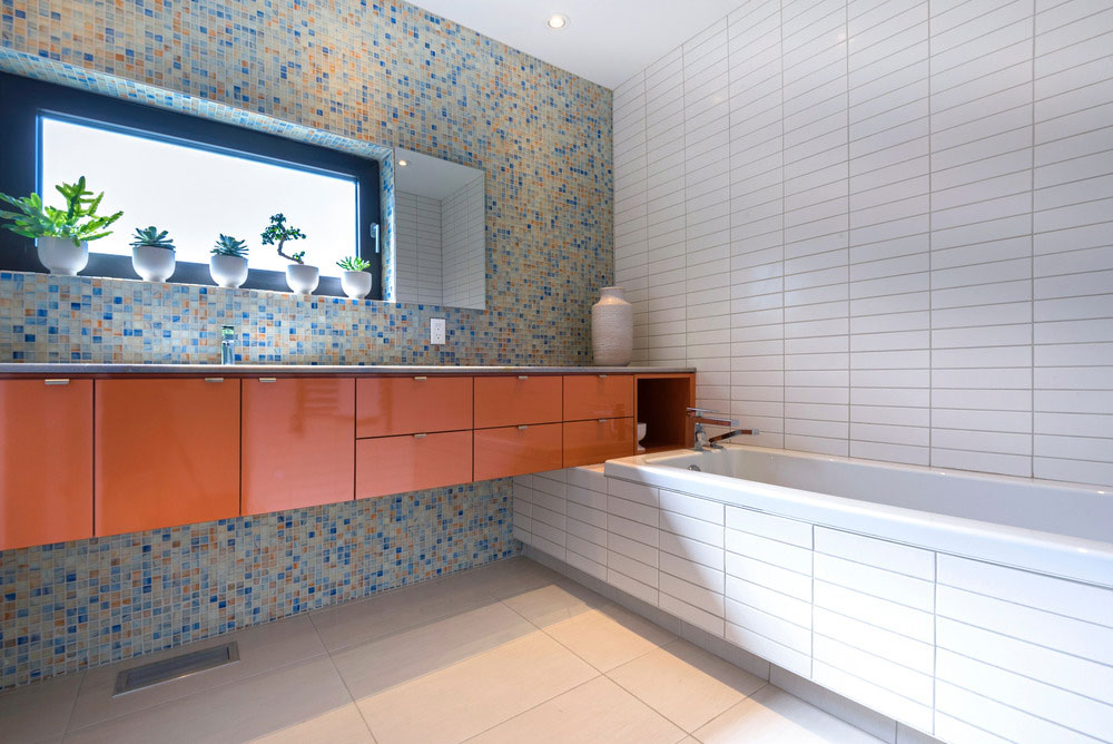 Koupelna je dle přání majitelů rozdělena na tři samostatné jednotky: umývací část s umyvadlovými skříňkami v konzolové variantě a vanou, a dále sprchový kout a toaletu. FOTO ALBERTO BISCARO
