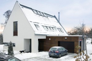 Hlavní hmotu domu se sedlovou střechou doplňuje kubická hmota garáže, kterou odlišuje kromě tvaru i pojetí fasády.
