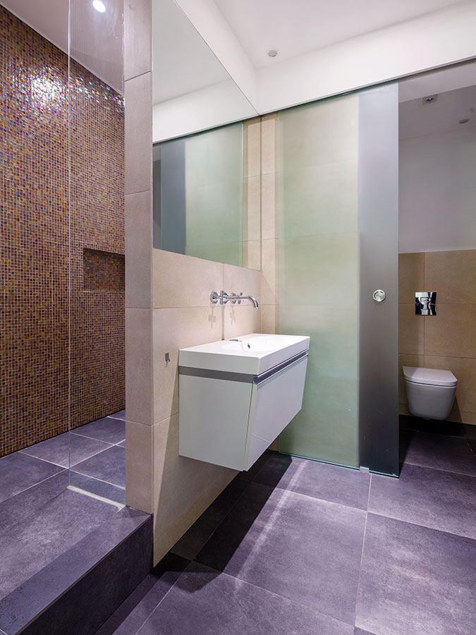 První z koupelen umožňuje majitelům dopřát si pohodlnou sprchu ve velkorysém sprchovém koutě.