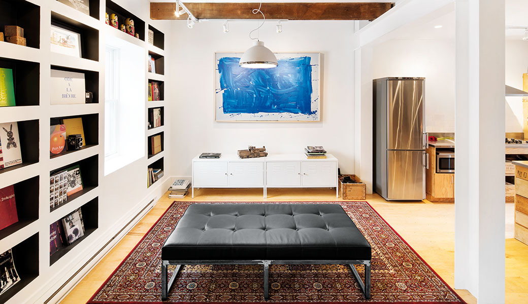 Obývák netradičně. Prostor obývacího pokoje vyřešili mladí designéři neobvykle – místo klasické pohovky zvolili jen jednoduché sezení bez opěrky. Televizi nahradil obraz s uklidňující modrou. FOTO ADRIEN WILLIAMS