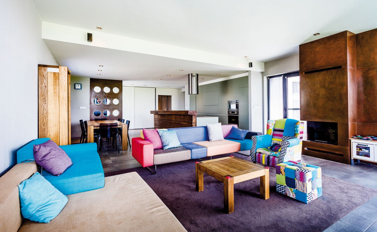 Obývací části dominuje barevná textilní sedačka s nápaditým křeslem, jehož veselý design odráží povahu rodiny. Domácí paní plánuje v blízkém čase dotvořit interiér obrazy. FOTO WIENERBERGER