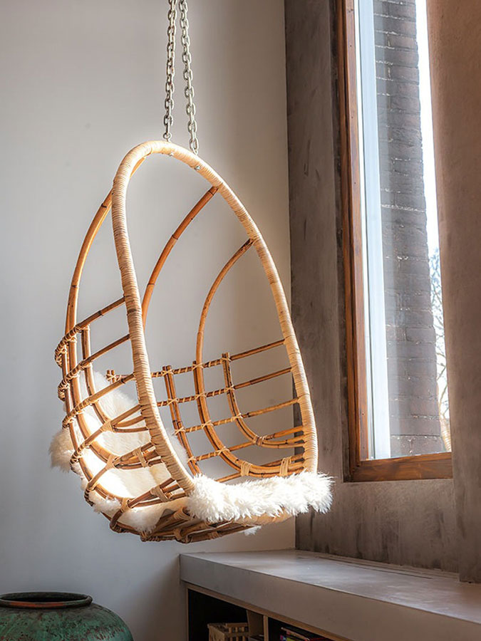 Jedním z přidaných dřevěných designových doplňků je visící křeslo – houpačka, z níž je možné přes velké okno pozorovat okolní svět. Foto: Teo Krijgsman