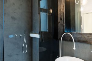 V koupelně vznikla velká walk-in sprcha s kouřovým prosklením, na kterou navazuje pult s umyvadly. Foto Martin Zeman