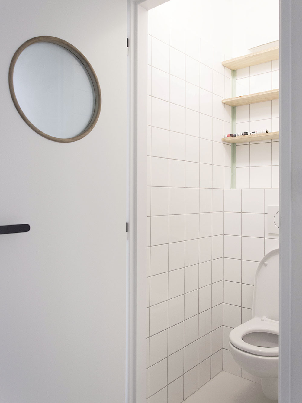 Toaletu a koupelnu charakterizuje jednoduchý bílý obklad. Menší čtvercový formát působí moderně a současně retro. FOTO SCHWESTERN