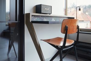 V pokoji jsou dva minimalistické psací stoly. Architektka k nim přidala jednoduché dřevěné židle Marko chairs. foto Jakub Skokan a Martin Tůma z BoysPlayNice