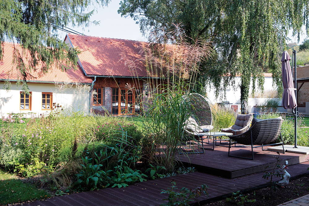 Uprostřed zahrady s bujně rostoucí zelení vzniklo odpočinkové místo s pohodlnými křesly. foto Robert Žákovič