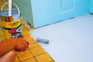 21. NÁTĚR PODLAHY Nylonovým válečkem nanášíme důkladně rozmíchanou barvu na podlahu. Díky dlaždicím se nám jednoduše vymezují pracovní úseky. Foto Marcela Gigelová