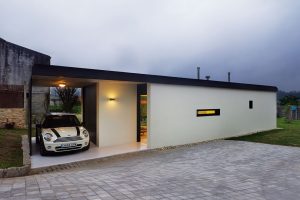 Střecha vystupuje mimo samotný objem domu a nabízí tak kryté stání pro jeden automobil. Foto HECTOR SANTOS DIEZ
