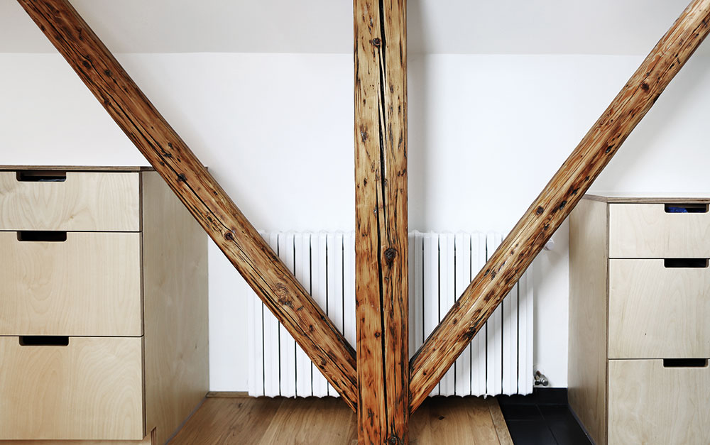 V interiéru vynikají původní trámy v kombinaci s březovým dřevem hlubokých zásuvek. Foto TRAGA