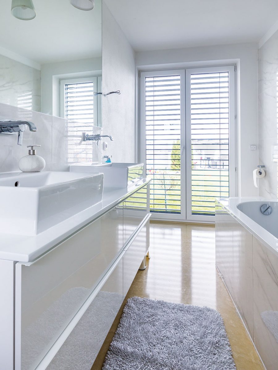 Koupelna v bílé barvě s litou béžovou podlahou působí čistě a útulně. Foto MIRO POCHYBA