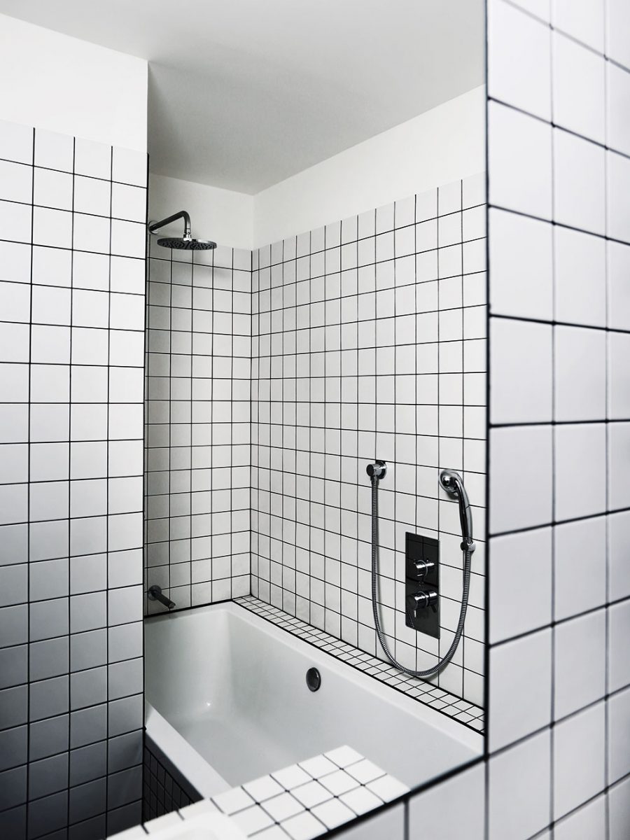 Částečným zasunutím vany za toaletu vznikl zároveň zapuštěný sprchový kout. Foto TRAGA