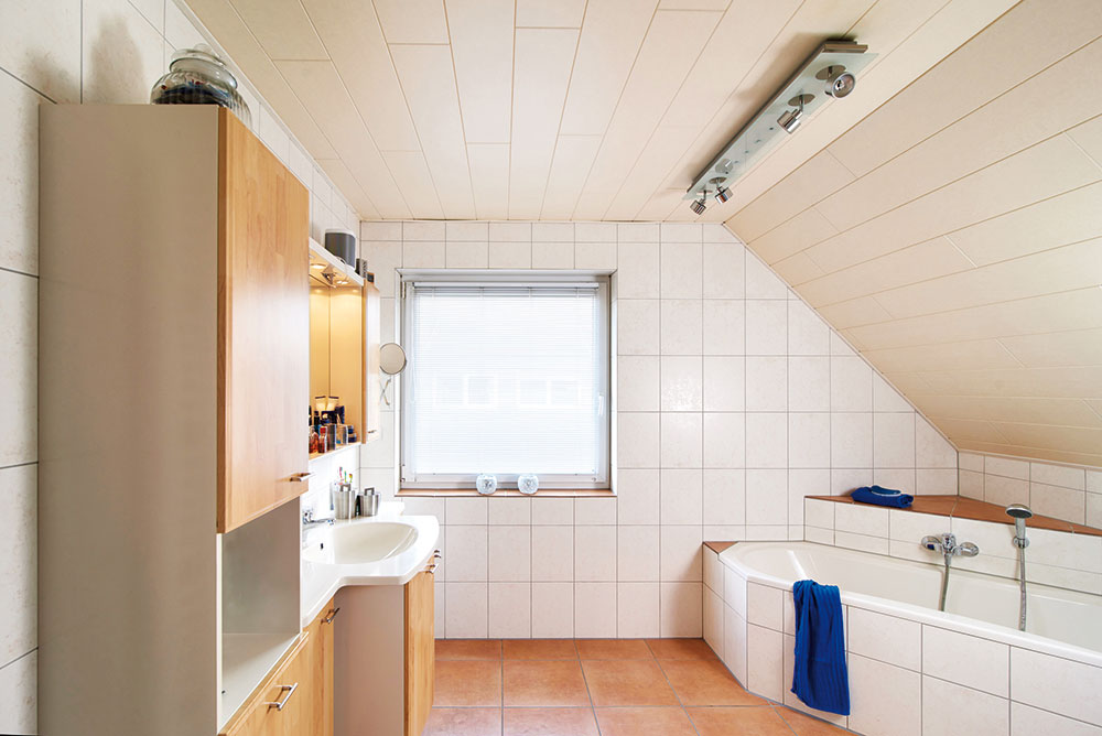 1 Původní stav. Koupelně dominovala v rohu umístěná vana a nábytek s dvířky ve světlém dekoru dřeva. FOTO VIEGA, ROSE BENNINGHOFF