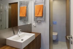 Dřevo v kombinaci s bílou a šedou barvou se objevuje i v koupelně. Větší obdélníkové obklady pokrývají stěny i podlahu. FOTO FOTES, JIŘÍ VANĚK