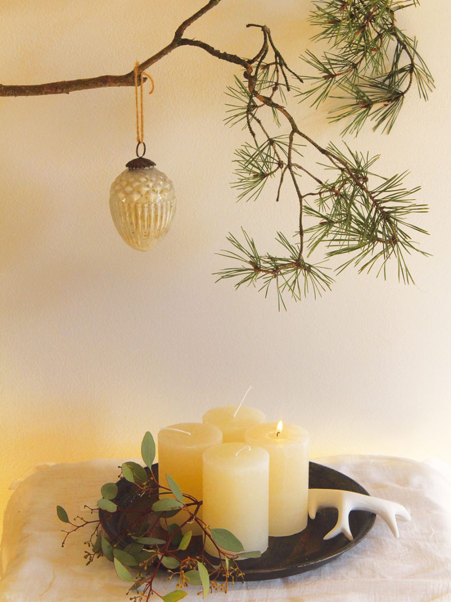Adventní svícen nemusí být vždycky v podobě kulatého jehličnanového věnce. Minimalistickou formou adventního svícnu může být i plechový tácek s klasicky čtyřmi svíčkami. Tácek lze dozdobit buď tradičnější větvičkou jedle (Abies), nebo například eukalyptem (Eucalyptus), popřípadě lze dekoraci v průběhu adventu stále pozměňovat či dozdobovat. FOTO KVĚTERIE