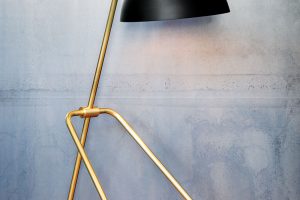 Stolní lampička Grue (50,2 x 22,9 cm) z kolekce Waldorf kombinuje otevřené půlkulové stínidlo s cylindrickým krytem zásuvky. Praktické otočné stínidlo je umístěno na stabilní minimalistické trojnožce.  