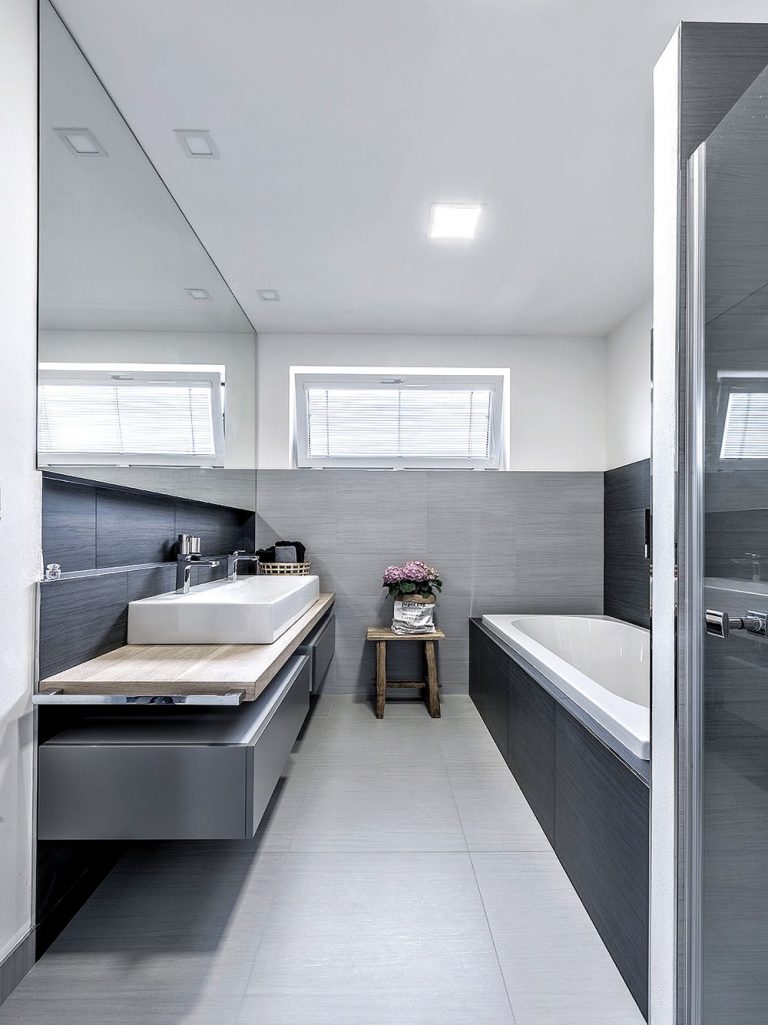 Přestože je koupelna relativně úzká, opticky ji zvětšuje velké zrcadlo nad umyvadlem. FOTO KLÁRA DAVIDOVÁ