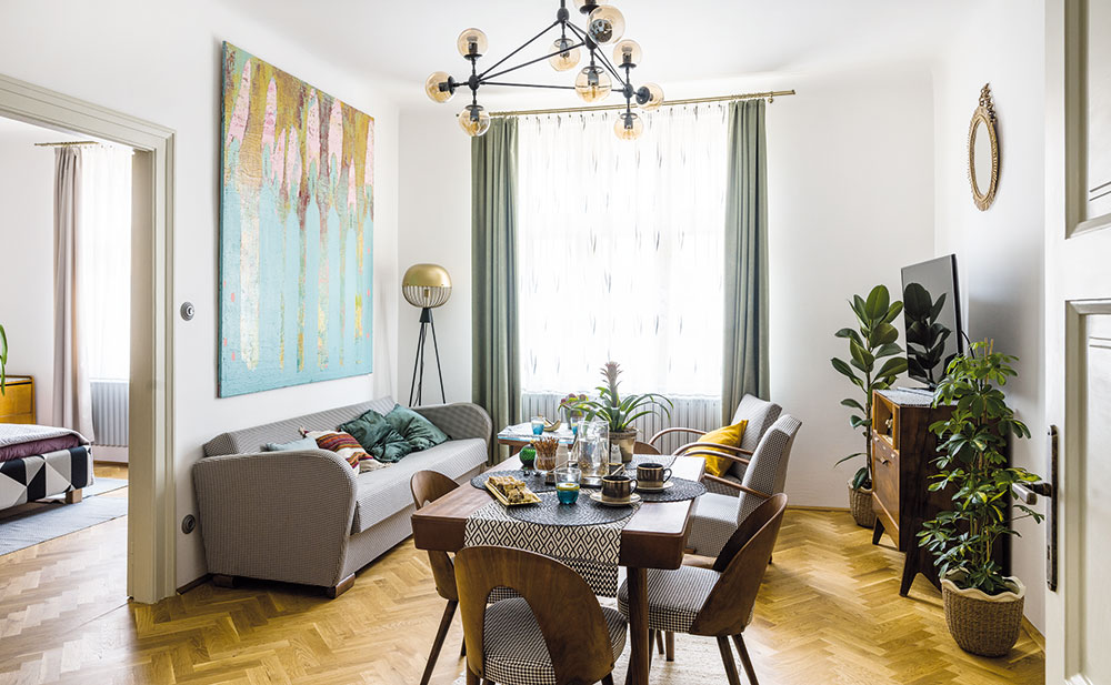 Centrem obývacího pokoje je dřevěný jídelní stůl, který doplňují známé židličky z firmy Tatra nábytek Pravenec (vyráběly se tu asi v letech 1960–1970). „Umístění stolu si vlastně prostor určil sám,“ tvrdí majitelka. FOTO NORA A JAKUB ČAPRNKOVI