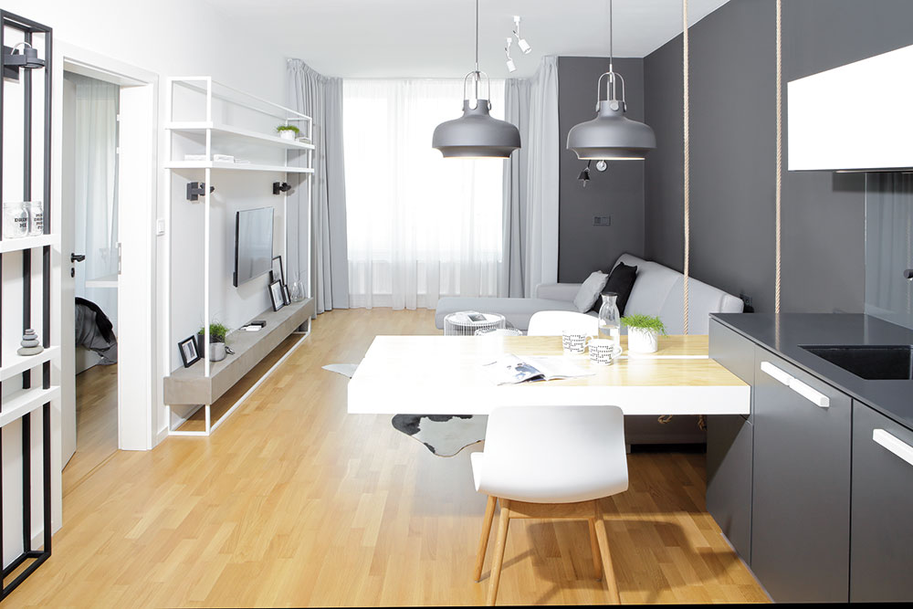 Úzký prostor opticky zvětšují barvy. Stěny v bytě jsou vymalované bílou a tmavě šedou barvou, ve stejném odstínu je provedena také kuchyňská linka. FOTO ROBERT ŽÁKOVIČ