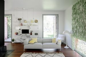 Nejvýraznějším prvkem obývacího pokoje je nástěnná dekorace. Zelená s bílou a přírodním dřevem se v domě opakují. FOTO JULIEN KERDRAON