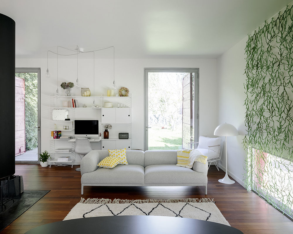 Nejvýraznějším prvkem obývacího pokoje je nástěnná dekorace. Zelená s bílou a přírodním dřevem se v domě opakují. FOTO JULIEN KERDRAON