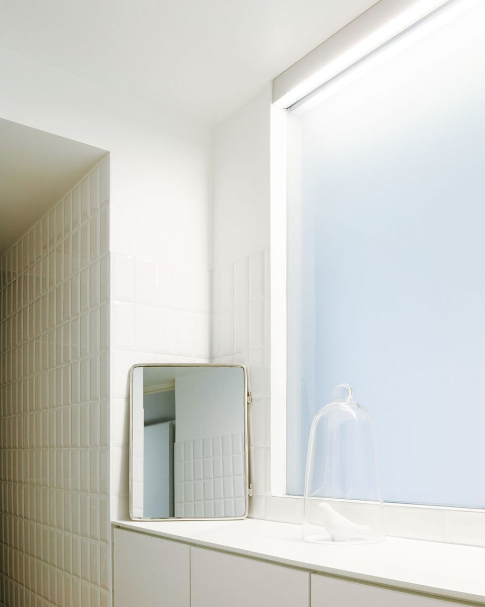 Koupelna s volně stojící vanou je obložena bílým lesklým obkladem. Velkoformátová dlažba opticky zvětšuje prostor. FOTO JULIEN KERDRAON