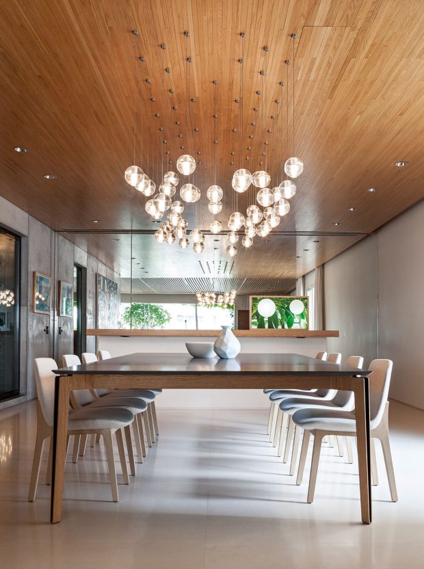 Pojítkem je dřevěný strop. Nad jídelním stolem jsou v něm instalovány oblíbené skleněné koule od značky Bocci.. FOTO RUI TEIXEIRA