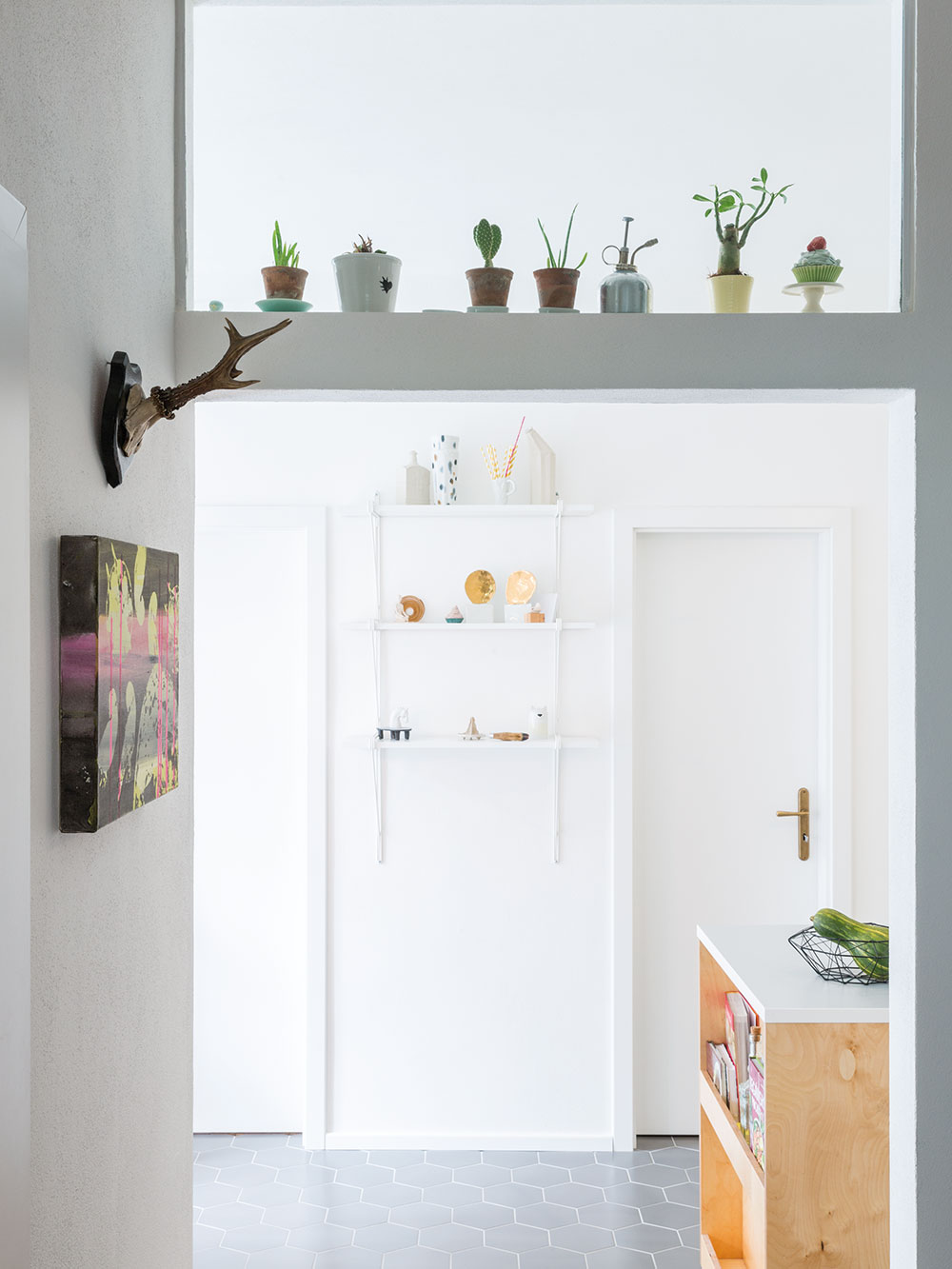 V otevřeném průhledu z obývacího pokoje do kuchyně dominuje bílá barva a pokojové rostliny, které mají v bytě výborné podmínky. FOTO JURAJ STAROVECKÝ