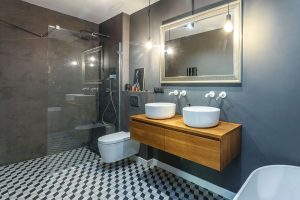 Koupelnový nábytek je vyrobený na míru. Stěny sprchového koutu jsou ošetřeny cementovou stěrkou, která se dá snadno udržovat. FOTO JH STUDIO