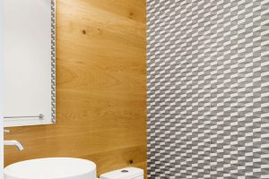 V koupelně zvolila designérka pro obklad stěn kombinaci přírodního dřeva a dlažby s výrazným dekorem. FOTO ADRIEN WILLIAMS