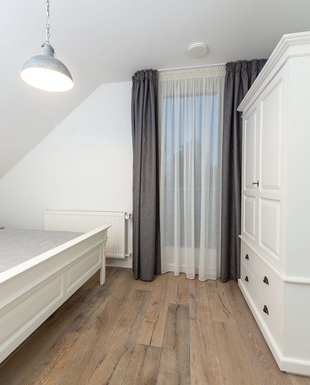 V ložnicích pro hosty jsou kromě manželských postelí i velké bílé skříně z masivu, které prostor zbytečně opticky nezatěžují a poskytují dostatek úložného prostoru. FOTO MIRO POCHYBA