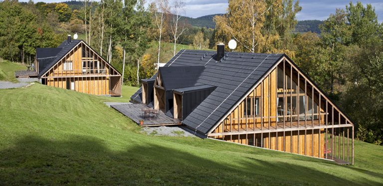 Vedle sebe vyrostly dvě moderní dřevěné chaty podle starých principů