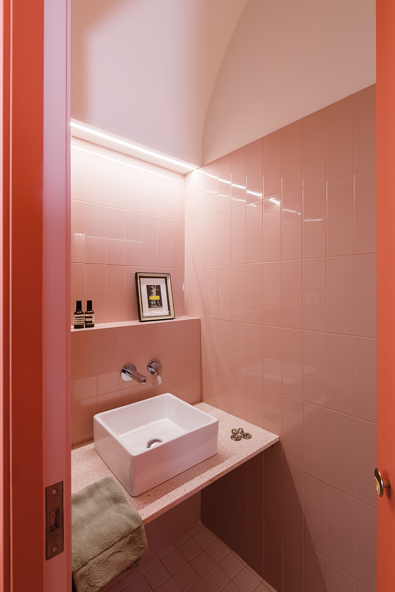 Koupelnu pro hosty umístili architekti do obloukovitého boxu, který dosahuje téměř ke stropu, ale neomezuje otevřený prostor.