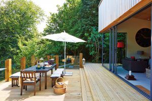 Volný přechod z obývacího pokoje na terasu s výhledem na zahradu a okolní zeleň je ideální dispozicí pro letní pobyt. FOTO UNIQUE HOME STAYS UK